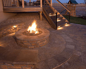 An outdoor fire pit with brick pavers built by installers