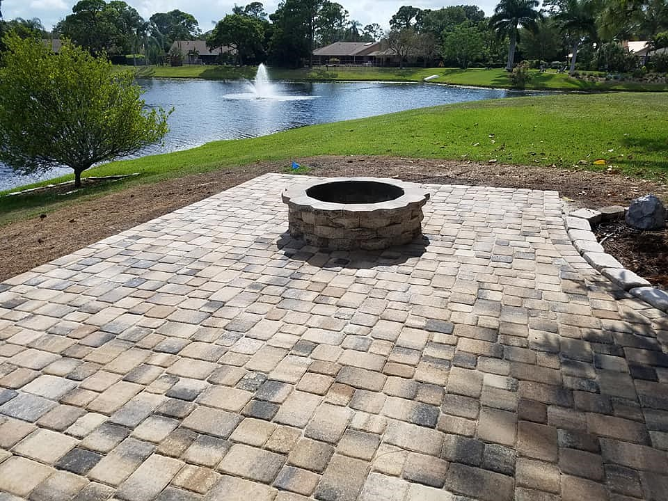 A circular fire pit near a lake built by a fire pit contractor