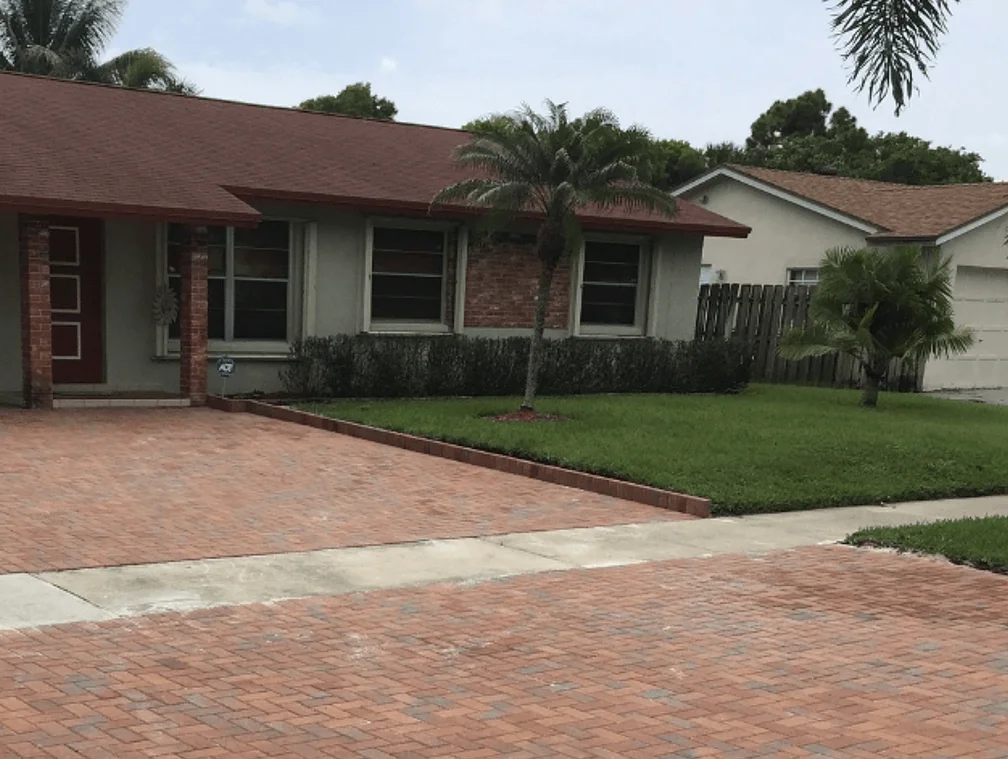 A small retaining wall built next to a driveway to support the lawn