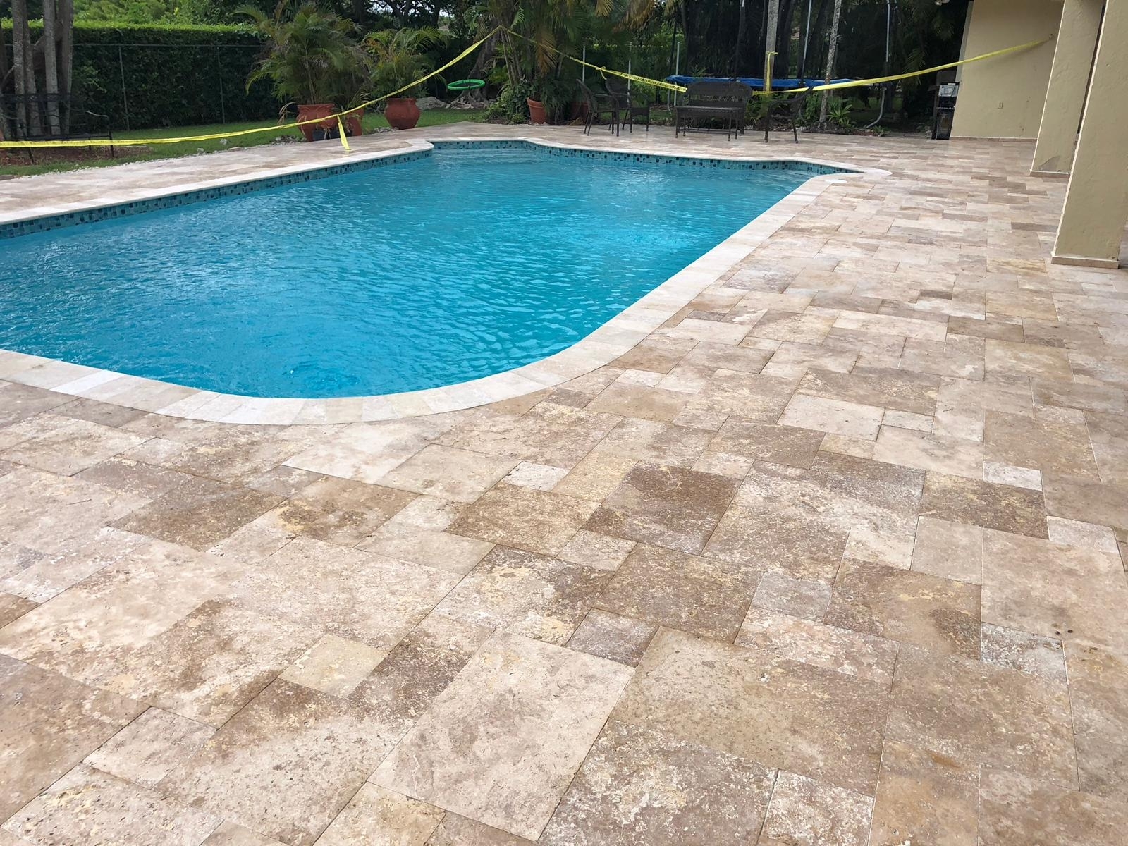 Marble pavers, the best pavers for a pool deck, around a pool.