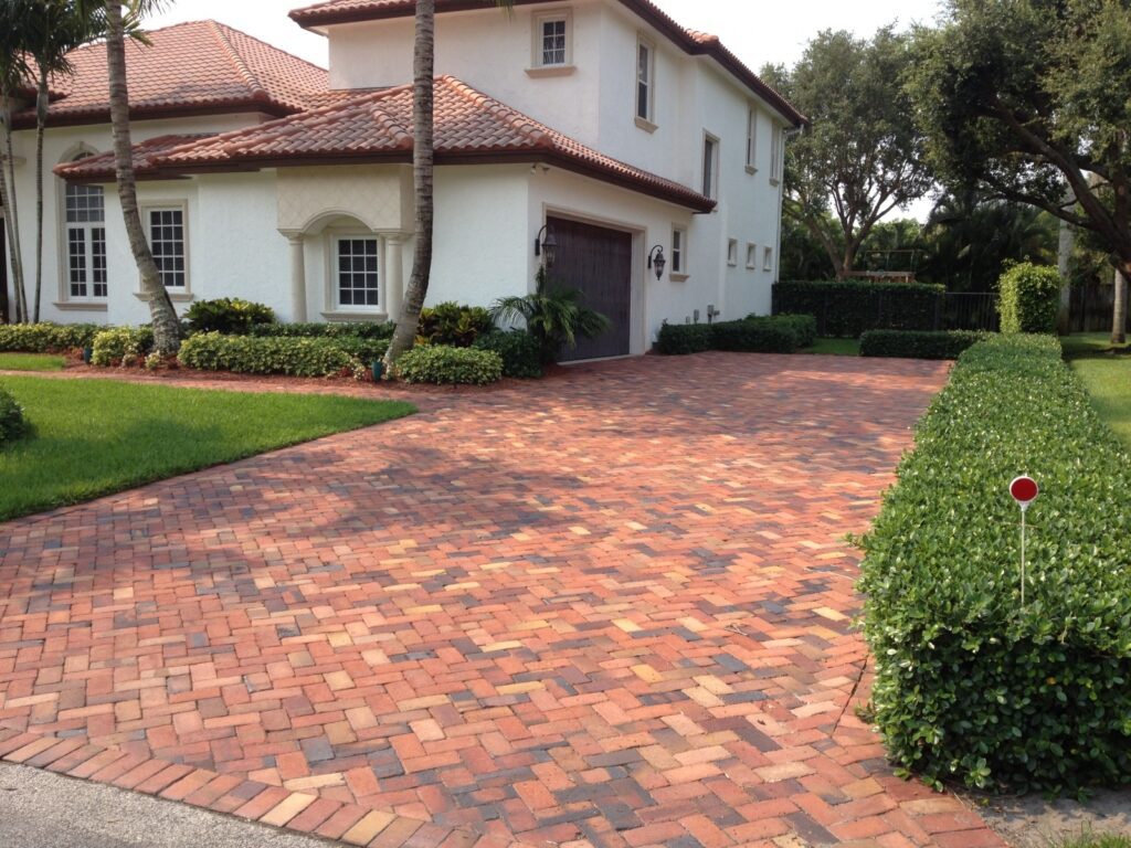 A clay Herringbone 90 driveway leads to a double-story house