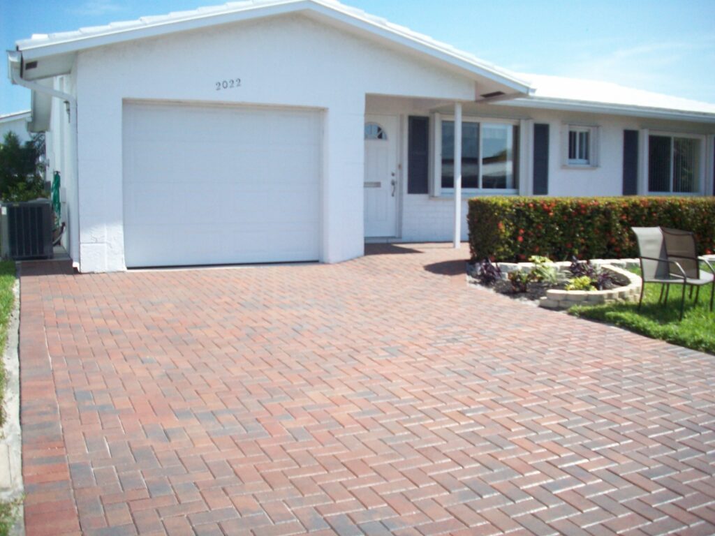 A red brick Herringbone 90 driveway leading to a house with a garage